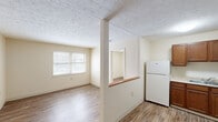 Located at 3716 Trent Cir in Lexington, KY, this one-bedroom, one-bathroom unit offers a practical and comfortable layout across a single floor. Wood-look flooring runs throughout the main living areas and bedroom, providing a warm, cohesive aesthetic that ties the space together.

The living room receives natural light through a set of windows, creating a bright and welcoming atmosphere. A structural column with a half-wall pass-through visually separates the living area from the kitchen, maintaining an open feel while defining each zone. Textured ceilings are consistent throughout the unit.

The kitchen is well-equipped, featuring rich warm-toned wood cabinetry, a single-basin sink, a white electric range, and a full-size refrigerator. Ample counter and cabinet space makes this an efficient area for everyday cooking.

The bedroom is a comfortable size, with wood-look flooring, a window for natural light, and access to two closets offering generous storage. The full bathroom includes a shower/tub combination with a white surround, a toilet, and tile flooring, keeping the space clean and functional.

Two closets provide practical storage solutions throughout the unit. Overall, the space presents a clean, neutral palette with cream-toned walls throughout, making it easy to personalize and move into.