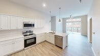 This contemporary apartment, located at 900 3rd St SE in Cedar Rapids, IA, offers 1010 square feet of well-designed living space. The single-floor layout includes two bedrooms, two bathrooms, and an open-concept living area. The kitchen is a highlight, featuring crisp white cabinetry, stainless steel appliances, and a practical L-shaped design with ample counter space. Light wood-look flooring in the kitchen and living areas contrasts beautifully with plush carpeting in the bedrooms, creating a cohesive yet varied aesthetic.

The primary bedroom, measuring 170 square feet, provides a generous retreat with a large window allowing natural light to flood the space. Both bathrooms are finished with modern fixtures and neutral tones, complementing the overall design. The apartment benefits from recessed lighting throughout, enhancing the sense of space and brightness.

Storage solutions are thoughtfully integrated, including a dedicated closet and wire shelving systems. Large windows in the bedrooms and living area not only brighten the space but also offer views of the surrounding urban landscape. The apartment's neutral color palette and clean lines create a versatile canvas for various decorating styles, making it an ideal choice for those seeking a contemporary urban living experience.
