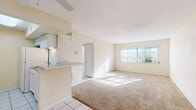 Located at 1060 Jasper St in Largo, Florida, this single-floor, two-bedroom, one-bathroom residence offers a practical and well-organized layout. The open-concept living and dining area is a central highlight, featuring warm neutral tones, plush wall-to-wall carpeting, a ceiling fan, and a large window that floods the space with natural light and offers a pleasant outdoor view. The kitchen connects seamlessly to the living area via a pass-through counter, and is equipped with white cabinetry, a subway tile backsplash, granite-style countertops, and tile flooring, providing ample storage and prep space. Both bedrooms are carpeted and bathed in natural light from windows with blinds, maintaining a clean, neutral aesthetic. The primary bedroom is generously sized and features a large sliding-door closet. An additional bedroom offers similar comfort and natural light. In total, the residence includes four closets, providing notable storage throughout. The full bathroom features tile flooring, a shower-tub combination, and a window for natural ventilation. A dedicated hallway and entrance complete the layout, offering a logical flow between all areas of the home.
