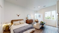 Located at 514 S Weber St in Colorado Springs, CO, this efficiently designed 2-bedroom, 1-bathroom unit offers a contemporary living experience on a single floor. The open layout makes smart use of every square foot, with wood-look plank flooring flowing consistently throughout the space.

The kitchen is outfitted with light wood-tone flat-front cabinetry, white quartz countertops, a classic subway tile backsplash, and a full suite of stainless steel appliances including a refrigerator, electric range, and over-the-range microwave. A window in the kitchen area brings in natural light and outdoor views.

The spacious primary bedroom is a bright, airy retreat featuring high ceilings, multiple windows that invite generous natural light, a sliding closet, and ample room for a full sitting area. The second bedroom offers a similarly clean, minimalist aesthetic.

The bathroom is finished with a light wood vanity, white quartz countertop, a large mirror, wood-look tile flooring, and a shower-tub combination. Additional conveniences include an in-unit laundry area, a dedicated closet, and an electrical panel accessible from a central hallway. The overall ambiance is modern and clean, with a neutral palette and contemporary black hardware accents tying the design together cohesively.