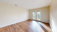 This 740 square foot apartment in Louisville, KY offers a well-designed living space with two bedrooms and one bathroom. The living room is a standout feature, boasting beautiful hardwood floors and French doors that flood the space with natural light. These doors likely lead to a small balcony or patio area, enhancing the indoor-outdoor living experience.

The kitchen, while compact, is efficiently designed with wooden cabinetry, granite countertops, and white appliances. The layout suggests an open concept between the kitchen and living areas, promoting a sense of spaciousness in the modest floor plan.

Both bedrooms feature plush carpeting for comfort, with the primary bedroom measuring a generous 160 square feet. Large windows in the bedrooms ensure ample natural light. The bathroom is outfitted with modern fixtures, including a vanity with storage and a shower-tub combination.

Throughout the apartment, neutral wall colors and white trim create a clean, contemporary aesthetic. The use of different flooring materials - hardwood in living areas and carpet in bedrooms - helps to define separate spaces within the open plan.

Storage appears to be well-considered, with closet space visible in the bedrooms. The overall layout maximizes the available 740 square feet, creating a comfortable and functional living space ideal for individuals or small families seeking an urban dwelling.