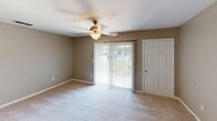 Located at 2705 Nottingham Ln in Monroe, NC, this single-floor home offers a practical and comfortable layout designed for everyday living. The main living area is carpeted and bathed in natural light, with a ceiling fan overhead and a sliding glass door fitted with vertical blinds that opens to outdoor views, creating a bright and airy atmosphere. A hardwood-style entry mat at the front door provides a welcoming transition into the space.

The kitchen is efficiently designed and connects to the living area via a convenient pass-through window with a breakfast bar counter. It features warm honey-toned wood cabinetry with decorative raised-panel doors, light speckled countertops, a black electric range with a built-in range hood, and a double sink — offering a functional cooking environment.

The bedrooms are carpeted and well-proportioned, each equipped with ceiling fans and natural light from windows with blinds. Closet space is plentiful, with multiple bedrooms offering dedicated closets, including a walk-in closet in the primary suite. The primary bedroom also includes an en-suite bathroom with bold accent wall coloring, a toilet, and access to a separate closet area.

The bathroom features a full tub-shower combination, a vanity with mirror, and chrome fixtures, completing this well-rounded single-level home.