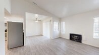 Located at 7875 S Candlestick Ln in Midvale, Utah, this single-floor, one-bedroom, one-bathroom residence offers a thoughtfully designed layout making efficient use of its space. The open living room is bright and welcoming, featuring light gray wood-style flooring, multiple windows with white blinds that invite natural light, and a classic black fireplace as a central focal point. A ceiling fan adds comfort to the adjoining area, which connects seamlessly to the rest of the home. The kitchen is clean and modern, showcasing white shaker-style cabinetry with matte black hardware, light quartz countertops, a full suite of stainless steel appliances including a refrigerator, dishwasher, microwave, and range, and recessed lighting overhead. The bedroom offers a comfortable, carpeted retreat with neutral walls and a window dressed with white blinds, providing a quiet and restful environment. The bathroom is finished with wood-look vinyl flooring, a white vanity with storage cabinetry above, and a full tub-shower combination accented by a curved black curtain rod and black hardware details. The home's consistent neutral palette and clean finishes create a cohesive, move-in-ready atmosphere throughout.