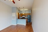 Located at 1931 Martin Luther King Jr. Blvd in New Orleans, LA, this single-story 2-bedroom, 1-bathroom unit offers a practical and well-appointed layout. Hardwood-style flooring runs throughout the living areas and bedrooms, complemented by neutral wall tones that create a clean, cohesive aesthetic. Ceiling fans are installed in multiple rooms, aiding comfort and airflow.

The kitchen is a standout functional space, featuring warm wood cabinetry, dark countertops, a stainless steel sink, a black range, and a full-size refrigerator. A peninsula with pendant lighting opens toward the living area, enhancing the sense of connectivity between spaces. A tall pantry cabinet provides generous storage.

The primary bedroom offers a comfortable footprint with high ceilings, a ceiling fan, and access to closet space. The second bedroom benefits from natural light through a window with outdoor greenery views and also includes a ceiling fan. An in-unit stacked washer and dryer is conveniently accessible from one of the bedrooms.

The bathroom includes a tub-shower combination, a vanity with storage, and tile flooring. Grab bars are also present, adding accessibility. Overall, the unit presents a straightforward, functional layout well-suited for everyday living in the heart of New Orleans.