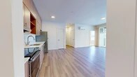 Located at 849 E Magnesium Ave in Spokane, WA, this thoughtfully designed 3-bedroom, 1-bathroom unit offers a clean, contemporary aesthetic throughout its single-floor layout. The open-concept living and kitchen area serves as the heart of the unit, featuring light wood-style luxury vinyl flooring, recessed lighting, and a wall-mounted mini-split system for year-round climate control. The kitchen is outfitted with flat-front wood-toned cabinetry extending to the ceiling, light countertops, a stainless steel refrigerator, electric range, built-in microwave, and dishwasher — all designed for both function and style. The living area flows seamlessly toward large sliding glass doors that open to a private balcony, filling the space with natural light and offering open views of the surrounding landscape. Each of the three bedrooms is carpeted for comfort and features generous windows that bring in additional natural light, with outdoor views visible from multiple rooms. The bathroom is finished with a wood-toned vanity, modern hardware, and a large mirror. A dedicated closet provides practical storage. The unit's neutral color palette, modern finishes, and cohesive design make it a bright and functional living space.