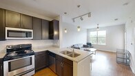 Located at 2101 Arlington Blvd in Charlottesville, VA, this one-bedroom, one-bathroom unit offers a well-designed, efficiently organized layout across a single floor. The open-concept living and kitchen area is bright and welcoming, featuring warm hardwood-style flooring and a ceiling fan that enhances airflow and comfort. Large windows flood the living room with natural light and offer views of the surrounding greenery, creating an airy, relaxed ambiance.

The kitchen is a standout feature, equipped with dark espresso cabinetry, granite countertops, stainless steel appliances, and a peninsula with bar seating illuminated by pendant lighting — ideal for casual dining or entertaining. The living area flows naturally from the kitchen, providing a cohesive and functional common space.

The bedroom is carpeted for comfort and includes a ceiling fan, a closet, and a sliding glass door that opens to a private balcony with outdoor views — a charming retreat. An additional door in the living area also provides balcony access, further enhancing the connection to the outdoors.

The bathroom is finished with hardwood-style flooring, a dark vanity with an undermount sink, a wall-mounted mirror, and a full soaking tub with a shower. Clean, neutral tones throughout the unit create a calm and cohesive aesthetic well-suited for everyday living.