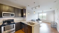 Located at 2101 Arlington Blvd in Charlottesville, VA, this one-bedroom, one-bathroom unit offers a well-designed, efficiently organized layout across a single floor. The open-concept living and kitchen area is bright and welcoming, featuring warm hardwood-style flooring and a ceiling fan that enhances airflow and comfort. Large windows flood the living room with natural light and offer views of the surrounding greenery, creating an airy, relaxed ambiance.

The kitchen is a standout feature, equipped with dark espresso cabinetry, granite countertops, stainless steel appliances, and a peninsula with bar seating illuminated by pendant lighting — ideal for casual dining or entertaining. The living area flows naturally from the kitchen, providing a cohesive and functional common space.

The bedroom is carpeted for comfort and includes a ceiling fan, a closet, and a sliding glass door that opens to a private balcony with outdoor views — a charming retreat. An additional door in the living area also provides balcony access, further enhancing the connection to the outdoors.

The bathroom is finished with hardwood-style flooring, a dark vanity with an undermount sink, a wall-mounted mirror, and a full soaking tub with a shower. Clean, neutral tones throughout the unit create a calm and cohesive aesthetic well-suited for everyday living.