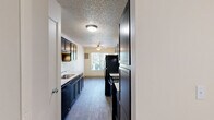 Located at 2040 SW Vermont St in Portland, Oregon, this one-bedroom, one-bathroom apartment offers a practical and comfortable single-floor layout. The combined kitchen and living area forms the heart of the unit, with the living room featuring plush carpeting, a textured ceiling, and a sliding glass door that opens onto a private balcony with pleasant outdoor views of surrounding greenery. The kitchen is outfitted with dark espresso cabinetry, light stone-look countertops, a stainless steel sink, and black appliances including a refrigerator, all set atop wood-look flooring that adds warmth to the space. The bedroom is generously sized, filled with natural light from a window, and includes a built-in sliding-door closet for convenient storage. The bathroom features wood-look flooring, a dark vanity with a stone-look countertop and undermount sink, and a full tub-shower combination. Throughout the unit, neutral warm tones on the walls and textured ceilings create a cohesive and inviting atmosphere. The dedicated closet and efficient layout make this apartment a functional and comfortable home in the SW Portland neighborhood.