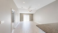 Located at 1413 NW High View Dr in Grain Valley, MO, this single-story, 3-bedroom, 1-bathroom home offers a well-designed layout with modern finishes throughout. The open-concept kitchen and living area serves as the heart of the home, where light wood-look tile flooring flows seamlessly underfoot. The kitchen is outfitted with crisp white cabinetry, dark granite countertops, a peninsula with additional counter space, and a full suite of stainless steel appliances including a refrigerator, range, microwave, and dishwasher. The adjacent living room features a vaulted ceiling with a ceiling fan, recessed lighting, and a sliding glass door that fills the space with natural light and provides outdoor access. The three bedrooms are carpeted and finished with neutral-toned walls, offering a comfortable and quiet retreat. The primary bedroom is a generous size, while the additional bedrooms each include closet space and windows for natural light. The bathroom is clean and functional, featuring a walk-in shower with sliding glass doors, a granite-topped vanity, and light wood-look tile flooring. Two hallways connect the living areas to the bedrooms, creating an efficient and practical floor plan throughout.