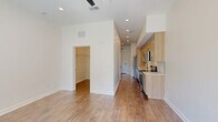 Located at 550 Great Circle Rd in Nashville, TN, this efficiently designed single-floor unit offers a clean, contemporary aesthetic throughout. The open-concept layout seamlessly combines the kitchen, dining, and living areas into one cohesive space, maximizing functionality. The galley-style kitchen is outfitted with light wood cabinetry, matte black hardware, stainless steel appliances including a range, microwave, dishwasher, and refrigerator, complemented by crisp white quartz countertops and a subtle geometric tile backsplash. Recessed lighting and wood-look flooring extend throughout, contributing to a bright, modern atmosphere. Natural light filters in through a glass-paneled entry door that opens to the patio, enhancing the open feel of the living area. The full bathroom features a light wood vanity with a stone-topped sink, a subway tile tub-surround, and consistent matte black fixtures that tie into the overall design language. In-unit laundry with a Whirlpool washer is tucked into a dedicated laundry room. Two closets, including a walk-in, provide ample storage. A utility room and dedicated entrance round out the floor plan, ensuring every square foot is purposefully utilized in this well-appointed Nashville residence.