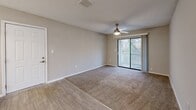 Located at 1500 Willow Trail Dr in Norcross, GA, this single-floor, 2-bedroom, 2-bathroom residence offers a well-organized layout designed for comfortable everyday living. The combined kitchen and living room serves as the heart of the home, where the kitchen stands out with its galley-style design featuring white shaker cabinetry, white countertops, a tile backsplash, stainless steel appliances, and wood-look flooring. The living area is carpeted, features a ceiling fan with light, and opens directly onto a private balcony through sliding glass doors, offering serene wooded views. Both bedrooms are carpeted and equipped with ceiling fans. The primary bedroom benefits from its own sliding door access to the balcony and includes a walk-in closet outfitted with wire shelving for ample storage. The second bedroom features a large window that brings in natural light. Each of the two bathrooms is clean and functional, with one featuring a full tub/shower combination, wood-look flooring, a white vanity, and brushed nickel fixtures. A hallway connects the rooms, and neutral warm-gray tones throughout create a cohesive, move-in-ready aesthetic.