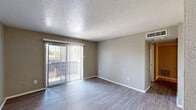 Located at 1265 Castle Dr in Garland, Texas, this single-floor residence offers a practical and comfortable layout designed for everyday living. The main living area is finished with durable wood-look vinyl flooring and neutral gray walls, creating a clean, modern aesthetic. A large sliding glass door fitted with vertical blinds opens directly to a private outdoor patio, allowing natural light to fill the space and providing easy access to the outdoors. The textured ceiling adds subtle architectural character throughout the common areas.

The kitchen is equipped with stainless steel appliances, including a refrigerator and range, complemented by light-toned countertops and white cabinetry, offering a straightforward and functional workspace. The bathroom features a full tiled tub-and-shower combination with chrome fixtures and wood-look flooring, maintaining a cohesive style throughout.

The bedrooms are carpeted for comfort and each includes dedicated closet space with built-in shelving for organized storage. Ceiling fans with integrated lighting are installed in the bedrooms, contributing to year-round comfort. Windows fitted with blinds allow for natural light while maintaining privacy. The overall layout, as seen in the dollhouse view, is well-organized and efficiently utilizes the available space, making this residence a well-rounded and move-in ready home.