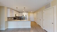 Located at 530 N Patterson Ave in Winston-Salem, NC, this single-floor unit offers a well-designed layout with modern finishes and a cohesive aesthetic throughout. The kitchen is a standout feature, showcasing white upper cabinetry, contrasting dark lower cabinets, a gray tile backsplash, and stainless steel appliances including a refrigerator, range, and microwave. A granite-topped island with pendant lighting serves as both a functional workspace and a visual centerpiece, while light wood-look flooring extends throughout the unit for a seamless, contemporary feel. The open layout connects the kitchen to the living area, offering a practical and inviting flow. The bedrooms are bright and airy, each featuring ceiling fans, large windows with horizontal blinds that invite natural light, and light wood flooring. One bedroom also includes a distinctive exposed wood post, adding a warm, industrial character to the space. The bathrooms are well-appointed with granite-topped dark vanities, soaking tubs, and clean, neutral finishes. A walk-in closet with wire shelving systems provides generous, organized storage. Additional closets are accessible throughout, further enhancing the unit's practicality. The overall ambiance is clean, modern, and move-in ready.