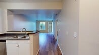 This 590-square-foot, one-bedroom, one-bathroom apartment at 4250 Glencoe Avenue in Marina del Rey, CA offers a thoughtfully designed single-floor layout. The open-concept living room and kitchen area serves as the heart of the unit, featuring warm hardwood-style flooring that extends throughout the space. The kitchen is equipped with stainless steel appliances, including a refrigerator and microwave, complemented by dark granite-style countertops and white cabinetry, with a peninsula that separates it from the living area. The 140-square-foot bedroom provides a comfortable retreat, featuring a large window with outdoor greenery views, a door to an exterior patio or outdoor access, and a dedicated closet. The full bathroom is finished with a white vanity, dark countertop, a tub-shower combo, and matching hardwood-style flooring, maintaining a clean and cohesive aesthetic. Natural light flows into multiple rooms through well-placed windows, enhancing the bright and airy ambiance of the unit. Clean neutral-toned walls, recessed lighting, and consistent flooring throughout tie the space together for a modern, move-in-ready feel in a desirable coastal Los Angeles neighborhood.