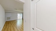 Located at 45 Euclid Ave in Hackensack, NJ, this 1-bedroom, 1-bathroom unit offers a well-organized single-floor layout with a clean, modern aesthetic throughout. Light wood-style flooring runs continuously across all living areas, creating a cohesive and bright interior.

The living room is a generous, open space featuring a sliding glass door that floods the room with natural light and provides direct access to an outdoor area with views of surrounding greenery. A separate entrance door and a closet add practical functionality to the space.

The kitchen is efficiently designed with crisp white shaker-style cabinetry, stainless steel appliances including a refrigerator, electric range, and over-the-range microwave, and light countertops — offering a modern and functional cooking environment.

The bedroom is a well-proportioned private retreat with a window that brings in natural light and views of the outdoors. White walls and the warm flooring create a calm and comfortable atmosphere.

The bathroom features a full tub-shower combination with white tile surround, a toilet, and a vanity with a light countertop, maintaining the clean, neutral palette of the rest of the unit.

A hallway connects the rooms, providing a logical and efficient flow throughout the unit. Overall, this space presents a fresh, updated interior well-suited for comfortable everyday living.