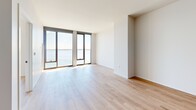 Located at 109 E Wilson in the heart of Madison, WI, this modern 2-bedroom, 1-bathroom residence offers a thoughtfully designed open-concept layout finished with light hardwood flooring throughout. The combined kitchen and living area serves as the heart of the home, featuring a well-appointed kitchen with wood-toned cabinetry, a subway tile backsplash, dark countertops, stainless steel appliances, and a freestanding island with a black metal frame — ideal for both meal prep and casual dining. The living area flows seamlessly toward floor-to-ceiling windows that frame breathtaking panoramic views of the lake, flooding the space with natural light. Both bedrooms continue the clean, contemporary aesthetic with the same warm hardwood flooring and large windows offering sweeping water views. The primary bedroom includes a spacious walk-in closet with a full adjustable shelving system. The bathroom is finished with modern fixtures, wood-toned cabinetry with dark countertops, black hardware accents, and a glass-enclosed walk-in shower. Recessed lighting and crisp white walls complete the refined, minimalist ambiance throughout this bright and well-appointed lakeside residence.