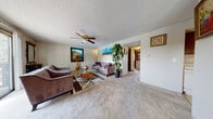 Located at 4141 S Seneca St in Wichita, Kansas, this single-floor home offers a well-organized layout with comfortable living spaces throughout. The living room is generously sized, featuring plush wall-to-wall carpeting, a ceiling fan, and a textured ceiling. A large sliding glass door fills the room with natural light and provides views of the surrounding trees, creating a bright and welcoming atmosphere. The galley-style kitchen is equipped with rich wood cabinetry, ample counter space, tile flooring, and includes a full-size refrigerator and electric range. Adjacent to the kitchen, the dining area accommodates a full dining set beneath a classic chandelier and features a window for added natural light. The primary bedroom offers carpet flooring, a ceiling fan, and a tranquil feel, while the second bedroom provides a cozy, functional space with a window. The bathroom features a marble-topped vanity with an undermount sink and a mirrored medicine cabinet, alongside a full soaking tub and shower combination. Throughout the home, textured ceilings and neutral wall tones create a cohesive and understated aesthetic, making this a practical and comfortable residence in Wichita.