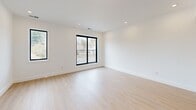 This thoughtfully designed 2-bedroom, 2-bathroom residence in Millis, MA offers a clean, modern aesthetic throughout its well-appointed single floor. Light hardwood flooring flows seamlessly from room to room, complemented by crisp white walls, recessed lighting, and bold black-framed windows that frame natural light and outdoor views.

The open-concept living, dining, and kitchen area serves as the heart of the home, providing a spacious and versatile gathering space. The kitchen is equipped with stainless steel appliances — including a range, microwave, and refrigerator — paired with shaker-style cabinetry in soft gray, white quartz countertops, and a convenient pantry for additional storage.

A central hallway connects the private quarters, where two generously sized bedrooms each feature black-framed windows and ample closet space. The primary bedroom is notably spacious and includes a large walk-in closet with built-in wire shelving systems.

Both bathrooms are finished to a high standard, featuring large-format marble-look tile, soaking tub and shower combinations with glass enclosures, warm wood vanities, and backlit LED mirrors. Together, they deliver a clean, spa-like experience. Three closets throughout the unit ensure plentiful storage for everyday living.