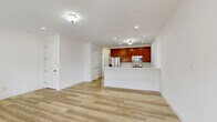 This well-appointed three-bedroom, three-bathroom home spans three floors, offering a generous and thoughtfully organized layout. The main level features an open-concept living, dining, and kitchen area bathed in natural light from multiple windows with classic white panel shutters. Light-toned hardwood flooring flows seamlessly throughout the living spaces, creating a clean, cohesive aesthetic. The kitchen is equipped with rich cherry-toned cabinetry, stainless steel appliances including a refrigerator, microwave, and range, as well as a peninsula with a white quartz countertop and double sink — ideal for both cooking and casual dining.

The entry level greets visitors with a bright foyer featuring a paneled front door with transom window, allowing additional natural light to fill the space. Each of the three bedrooms offers a comfortable footprint with light-toned flooring and windows with exterior views. The primary bedroom stands out with a tray ceiling and ceiling fan, along with dual windows that overlook surrounding trees. The three bathrooms are finished with matching cherry vanities and light countertops. Additional features include multiple closets, two pantries, a dedicated laundry area, and an unfinished basement with exposed framing and utilities, offering significant storage or future finishing potential.