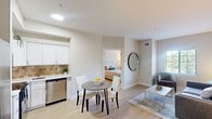 Located at 140 Holiday Blvd in Covington, Louisiana, this 1-bedroom, 2-bathroom unit offers a thoughtfully designed layout that maximizes every square foot. The living room features light hardwood-style flooring, neutral warm-toned walls, and a window with blinds that allows natural light to fill the space, creating a bright and welcoming atmosphere. The kitchen is outfitted with stainless steel appliances — including a full-size refrigerator, electric range, microwave, and dishwasher — complemented by white shaker-style cabinetry, a tile backsplash, and a dining area with space for a small table. The bedroom is a comfortable retreat with light flooring, natural light from a window with exterior views, and access to an adjoining area with built-in wire shelving for organized storage. Two full bathrooms each feature a tub-shower combination with a decorative curtain and tile flooring, providing practical functionality. Throughout the unit, the clean, neutral color palette and consistent flooring create a cohesive and calm aesthetic. The efficient floor plan ensures that each room is purposefully utilized, making this a practical and comfortable space in the heart of Covington.