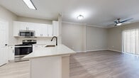 Located in Lewisville, TX, this well-appointed 2-bedroom, 1-bathroom residence offers a thoughtfully designed single-story layout with modern finishes throughout. Light wood-style flooring extends across the entire unit, creating a cohesive and airy feel.

The open-concept kitchen flows seamlessly into the living area and features crisp white shaker-style cabinetry, a tile backsplash, light quartz countertops, a peninsula with a built-in sink, and a full suite of stainless steel appliances including a refrigerator, range, and microwave. Crown molding accents both the kitchen and living area, adding an elevated touch to the space.

The living room is bright and welcoming, with a ceiling fan, crown molding, and a sliding glass door with vertical blinds that allows natural light to pour in. A connecting hallway leads to the bedrooms, each of which features neutral walls, a ceiling fan, and windows that bring in ample natural light. The spacious primary bedroom includes its own closet, while a second closet provides additional storage.

The bathroom is clean and functional, offering a full tub-shower combo, a white shaker vanity with a undermount sink, and matching black hardware accents. Wood-look tile flooring ties the bathroom together with the rest of the home's design aesthetic.