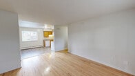 This one-bedroom, one-bathroom unit at 466 Ash St in Willimantic, CT offers a practical and comfortable single-floor layout. Light-toned hardwood flooring runs throughout the living spaces, lending warmth and continuity to the interior. The open living room is bright and airy, featuring large windows that invite natural light and offer views of the surrounding greenery, complemented by baseboard heating for year-round comfort. The kitchen is well-equipped with warm wood cabinetry, a sink with under-cabinet lighting, a dishwasher, and an electric range, along with a window that keeps the space well-lit. The bedroom is a comfortable size, featuring polished hardwood floors, a large window with outdoor views, and a built-in closet providing ample storage. Additional closet space is also found near the entryway. The bathroom is clean and functional, featuring a white vanity with a mirror, toilet, and a window for natural ventilation. Neutral white walls throughout the unit create a clean, move-in-ready aesthetic. Baseboard heating is present in multiple rooms, ensuring efficient warmth. This unit offers a straightforward, well-maintained layout suited for comfortable everyday living.
