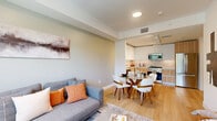 This contemporary 670 square foot apartment maximizes space and functionality. The single-floor layout includes one 130 square foot bedroom, two full bathrooms, and a dedicated office space. The heart of the home is an open-concept living area that seamlessly integrates the kitchen and living room, creating a spacious feel.

The kitchen boasts modern appliances, sleek cabinetry, and a efficient L-shaped design. Large windows throughout the apartment, including in the bedroom and office, flood the space with natural light and offer verdant outdoor views. The bathrooms feature modern fixtures, glass shower enclosures, and wood-toned vanities.

The apartment's design emphasizes clean lines and a neutral color palette, punctuated by pops of color in furnishings and decor. Hardwood floors run throughout, adding warmth to the space. The office area includes a stylish desk and ample room for productivity. Two hallways provide easy circulation and additional storage options.

Despite its compact size, the apartment offers a harmonious blend of style and practicality, ideal for modern urban living.
