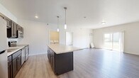 Located at 4800 46th St S in Fargo, ND, this well-appointed single-floor unit offers three bedrooms, two full bathrooms, and a thoughtfully designed layout. The open-concept kitchen and living area serves as the heart of the home, showcasing dark cabinetry, light granite countertops, a central island with pendant lighting, and a full suite of stainless steel appliances including a refrigerator, range, microwave, and dishwasher. Light hardwood-style flooring runs throughout the main living areas, lending a clean, modern aesthetic. The living room is bright and airy, with a sliding glass door that opens to a private balcony overlooking a green outdoor area, allowing natural light to fill the space. The bedrooms are carpeted for comfort and feature baseboard heating and windows that bring in additional natural light. The primary bathroom is finished with matching dark cabinetry, granite countertops, a large mirror, and a full tub-shower combination, while the second bathroom offers a clean, functional tub-shower unit. A dedicated in-unit laundry room comes equipped with a full-size washer and dryer. Two closets provide ample storage throughout the unit, completing this comfortable and functional home.