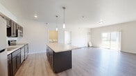 Located at 4800 46th St S in Fargo, ND, this well-appointed single-floor unit offers three bedrooms, two full bathrooms, and a thoughtfully designed layout. The open-concept kitchen and living area serves as the heart of the home, showcasing dark cabinetry, light granite countertops, a central island with pendant lighting, and a full suite of stainless steel appliances including a refrigerator, range, microwave, and dishwasher. Light hardwood-style flooring runs throughout the main living areas, lending a clean, modern aesthetic. The living room is bright and airy, with a sliding glass door that opens to a private balcony overlooking a green outdoor area, allowing natural light to fill the space. The bedrooms are carpeted for comfort and feature baseboard heating and windows that bring in additional natural light. The primary bathroom is finished with matching dark cabinetry, granite countertops, a large mirror, and a full tub-shower combination, while the second bathroom offers a clean, functional tub-shower unit. A dedicated in-unit laundry room comes equipped with a full-size washer and dryer. Two closets provide ample storage throughout the unit, completing this comfortable and functional home.