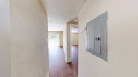 This one-bedroom, two-bathroom unit at 5316 Hull Street Rd in Richmond, Virginia offers a practical and well-organized single-floor layout. Warm-toned wood-style flooring runs throughout the entire space, lending a cohesive and inviting feel to each room.

The combined living, dining, and kitchen area serves as the heart of the unit. The living and dining space is bright and open, highlighted by a large sliding glass door with vertical blinds that floods the room with natural light and provides views of a grassy outdoor area. The kitchen features rich wood cabinetry, laminate countertops, white appliances including a range, refrigerator, and dishwasher, and a double-basin sink — offering functional storage and preparation space.

The bedroom is a comfortable, well-proportioned room with a window providing natural light and a built-in double closet with paneled doors, complemented by a second closet nearby for additional storage. The neutral, warm beige walls carry throughout the unit, creating a calm and consistent aesthetic.

The two bathrooms are clean and functional, each featuring wood-style flooring. One bathroom includes a tub/shower combination with white tile surround and safety grab bar. A utility room and electrical panel are also conveniently accessible within the unit.