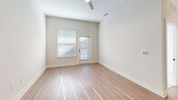 Located at 3801 Brody Dr in Greensboro, NC, this well-appointed one-bedroom, one-bathroom residence offers a smart, efficient layout across a single floor. The open-concept kitchen and living area serves as the heart of the home, featuring warm light wood-style flooring, tall ceilings with a ceiling fan, and a sliding glass door that fills the space with natural light. The kitchen is a standout, equipped with gray shaker-style cabinetry, stainless steel appliances, a white subway tile backsplash, and a large center island topped with elegant marble-look countertops, illuminated by modern pendant lighting. The bathroom showcases upscale finishes, including a wide double-vanity with light blue-gray cabinetry, marble-look countertops, matte black hardware, a large framed mirror, and stylish vanity lighting. The bedroom is carpeted for comfort, features large windows with blinds allowing ample natural light, and includes a dedicated closet. Neutral tones, clean lines, and consistent design details create a cohesive, modern ambiance throughout the entire residence. A dedicated closet adds practical storage to complement the well-organized floor plan.