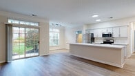 Located at 5407 Edwards Plantation Dr in Columbus, Ohio, this single-floor residence offers a thoughtfully designed open-concept layout that seamlessly connects the living, dining, and kitchen areas. Light-toned luxury vinyl plank flooring runs throughout the main living spaces, complementing the neutral palette of the walls and textured ceilings. Large windows and a sliding glass door with transom panels flood the living area with natural light and provide views of the surrounding greenery outside.

The kitchen is a standout feature, outfitted with white shaker-style cabinetry, white quartz countertops, a hexagonal tile backsplash, and a full suite of stainless steel appliances including a refrigerator, range, microwave, and dishwasher. A central island with an integrated sink adds both functionality and a natural gathering point.

The bedrooms are carpeted for comfort, with generous windows that bring in additional natural light. At least one bedroom includes access to a spacious walk-in closet with wire shelving systems for organized storage. The bathroom features a full tub-shower combination with tiled surround and built-in shelving, finished with chrome fixtures and wood-look flooring.

A dedicated laundry area accommodates a full-size washer and dryer, adding everyday convenience to this well-appointed home.