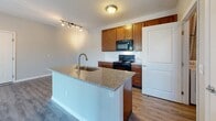 Located at 2980 Mark Andrew Dr in Columbus, OH, this single-floor unit offers a well-designed, open-concept layout that seamlessly connects the kitchen and living areas. The kitchen is a functional centerpiece, featuring warm wood cabinetry, granite countertops, a tile backsplash, and a peninsula island with a built-in sink — ideal for both meal preparation and casual dining. Black appliances, including a range, over-the-range microwave, and refrigerator, complement the kitchen's classic aesthetic. Track lighting adds a modern touch to the space.

The living area transitions smoothly from the kitchen, highlighted by durable hardwood-style flooring that extends throughout the main areas, while plush carpeting adds comfort to the bedroom spaces. The bedrooms are bright and generously sized, with neutral tones and natural light from windows with blinds. A large walk-in closet with wire shelving provides ample storage. A dedicated laundry area houses a full-size top-loading washer and dryer, adding everyday convenience. The unit also includes a utility closet with a Carrier HVAC system and an A.O. Smith water heater, ensuring reliable mechanical infrastructure throughout.