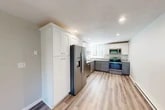 Located at 508 Ivy Ridge Rd in Syracuse, NY, this two-bedroom, one-bathroom unit offers a well-designed single-floor layout with modern finishes throughout. The open kitchen and living area serves as the heart of the home, showcasing a beautifully updated kitchen with two-tone cabinetry — crisp white upper cabinets and grey lower cabinets — paired with granite countertops and a full suite of stainless steel appliances, including a French door refrigerator, electric range, over-the-range microwave, and dishwasher. Recessed lighting and light wood-tone luxury vinyl plank flooring complete the kitchen's clean, contemporary look. The living area extends from the kitchen and features a large sliding glass door that opens to an outdoor balcony, filling the space with natural light and providing outdoor views. Both bedrooms are carpeted and offer a quiet, comfortable atmosphere, with natural light from windows and closet storage. One bedroom includes a sliding-door closet. The bathroom is well-appointed with a white vanity, granite countertop, and coordinating flooring. Two dedicated closets provide additional storage. The unit's neutral color palette and updated finishes create a cohesive, move-in-ready environment throughout.