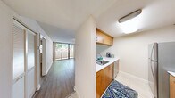 Located at Bull Run Road in the serene community of Miami Lakes, Florida, this well-appointed one-bedroom, one-bathroom unit offers a comfortable and functional layout across a single floor. The living area features warm light wood laminate flooring, neutral-toned walls, a textured ceiling, and track lighting, creating a bright and welcoming atmosphere. A pass-through counter connects the living space to the galley-style kitchen, which is equipped with warm wood cabinetry, white countertops, subway tile backsplash, stainless steel appliances including a refrigerator and range, and tile flooring — offering an efficient and stylish cooking space. The hallway leads to a dedicated closet with louvered doors, providing practical storage. The bedroom is carpeted and features a window with blinds that frames lush greenery outside, lending a calm, natural feel. The full bathroom includes a wooden vanity with a single sink, a wall-mounted mirror, and a separate room with a bathtub and toilet finished in clean white tile. Central air conditioning keeps the space comfortable year-round. A private balcony rounds out this unit, offering an outdoor retreat. This residence combines practical design with warm finishes in a tranquil Miami Lakes setting.