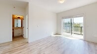 Located at 20221 53A Ave in Langley, BC, this well-appointed 2-bedroom, 1-bathroom residence offers a bright and modern living experience across a thoughtfully designed single floor. The open-concept kitchen and living area forms the heart of the home, anchored by a sleek white waterfall-edge island with an undermount sink and stylish pendant lighting. The kitchen features white cabinetry, a subway tile backsplash, and a full suite of stainless steel appliances including a refrigerator, electric range, and built-in microwave. Light-toned hardwood-style flooring flows throughout the main living areas, complementing the clean white walls and abundant natural light. Sliding glass doors lead from the living room to a private balcony, offering pleasant views of surrounding greenery. Both bedrooms are carpeted and filled with natural light through large windows that frame treetop and neighbourhood views, with baseboard heating ensuring year-round comfort. The bathroom is finished with white tile flooring and features a glass-enclosed walk-in shower. A dedicated laundry area houses a stacked Samsung washer and dryer, adding everyday convenience to this well-rounded home.