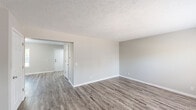 Located at 1010 W. Edgewood Blvd. in Lansing, Michigan, this two-story home offers a practical and well-organized layout across two floors. The main level features two living areas with durable wood-look vinyl plank flooring, neutral gray walls, and textured ceilings that carry a clean, updated aesthetic throughout. A connecting hallway leads to the front entry, giving the main floor an open and functional flow. The kitchen is a standout space, appointed with white shaker cabinetry, dark countertops, stainless steel appliances including a gas range and built-in microwave, and a double-basin sink beneath a window that fills the room with natural light. The upper level houses three bedrooms, each finished with plush carpeting, neutral tones, and windows that bring in ample daylight. The primary bedroom offers a generous footprint, while the additional bedrooms provide comfortable, well-proportioned spaces. A full bathroom serves the upper level, featuring a tub-shower combination, white cabinetry, and wood-look flooring consistent with the home's updated finishes. A utility room and dedicated closet add practical storage. The staircase connects both levels with ease, completing a home that is move-in ready and thoughtfully finished throughout.