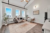 This two-story property offers 890 square feet of living space, efficiently divided between two floors of 450 square feet each. The home features two bedrooms, with the primary bedroom boasting a generous 450 square feet. The interior showcases a modern aesthetic with clean, white walls and warm wood-look flooring throughout.

The kitchen is equipped with contemporary white cabinetry, stainless steel appliances including a refrigerator, built-in microwave, and electric range. Ample counter space and a sleek design make it both functional and visually appealing.

The bedrooms are bright and airy, with the primary bedroom featuring high, vaulted ceilings that add a sense of spaciousness. Built-in closets provide storage, and the rooms are versatile enough to accommodate various furniture arrangements.

A hallway connects the living spaces, enhancing the flow of the home. The property also includes thoughtful touches like strategically placed lighting fixtures and a framed map on the wall, adding character to the space.

The overall design prioritizes simplicity and functionality, creating a comfortable living environment within a compact footprint. The property's address at 315 suggests a convenient urban or suburban location, though specific neighborhood details are not provided.