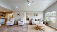 Located at 24541 Brookwood Ln in Taylor, Michigan, this single-story, 2-bedroom, 2-bathroom home offers a thoughtfully designed open-concept layout with modern finishes throughout. The living room is a standout space, showcasing dramatic vaulted ceilings, a ceiling fan, recessed lighting, and a large multi-pane window that fills the room with natural light. Durable wood-look flooring runs throughout the main living areas, complementing the home's clean, contemporary aesthetic. The kitchen and dining area share an open, connected layout. The kitchen is well-equipped with gray shaker-style cabinetry, granite countertops, a stainless steel appliance suite including a gas range, built-in microwave, dishwasher, and a large French door refrigerator. Abundant cabinetry and a pantry provide generous storage. The dining area offers an intimate setting with pendant lighting. The primary bedroom features vaulted ceilings, plush carpeting, a large window with outdoor views, and a ceiling fan. The second bedroom is equally comfortable with carpeting and a closet. Both bathrooms are finished with white vanities, granite countertops, and wood-look flooring. A dedicated laundry room and an attached garage add everyday convenience to this move-in-ready home.