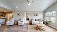 Located at 24541 Brookwood Ln in Taylor, Michigan, this single-story, 2-bedroom, 2-bathroom home offers a thoughtfully designed open-concept layout with modern finishes throughout. The living room is a standout space, showcasing dramatic vaulted ceilings, a ceiling fan, recessed lighting, and a large multi-pane window that fills the room with natural light. Durable wood-look flooring runs throughout the main living areas, complementing the home's clean, contemporary aesthetic. The kitchen and dining area share an open, connected layout. The kitchen is well-equipped with gray shaker-style cabinetry, granite countertops, a stainless steel appliance suite including a gas range, built-in microwave, dishwasher, and a large French door refrigerator. Abundant cabinetry and a pantry provide generous storage. The dining area offers an intimate setting with pendant lighting. The primary bedroom features vaulted ceilings, plush carpeting, a large window with outdoor views, and a ceiling fan. The second bedroom is equally comfortable with carpeting and a closet. Both bathrooms are finished with white vanities, granite countertops, and wood-look flooring. A dedicated laundry room and an attached garage add everyday convenience to this move-in-ready home.