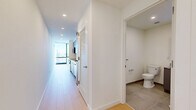 This 450 square foot apartment, located at 634 Newark Ave in Jersey City, NJ, offers a blend of efficiency and style. The space is comprised of one floor, featuring a generously sized 280 square foot primary bedroom and a hallway. The apartment boasts modern finishes throughout, with crisp white walls and warm, light-toned hardwood flooring creating a bright, airy atmosphere. Large windows flood the space with natural light and provide breathtaking views of the city skyline, including distant skyscrapers. The bedroom is equipped with sliding closet doors, maximizing storage while maintaining a sleek aesthetic. A recessed entryway adds architectural interest to the layout. The unit includes modern amenities such as recessed lighting and a wall-mounted HVAC unit for climate control. Despite its compact size, the apartment's thoughtful design and expansive views create a sense of spaciousness, making it an ideal urban dwelling for those seeking a contemporary living space in the heart of Jersey City.