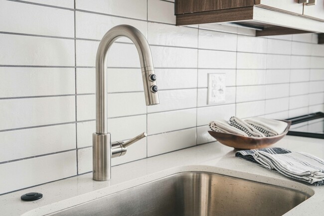 Modera Germantown kitchen boasts a sleek white subway tile backsplash and stainless steel hardware, adding a contemporary flair to your culinary haven - Modera Germantown