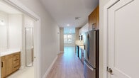 Located at 200 Middletown Blvd in Langhorne, PA, this efficiently designed single-floor unit offers a thoughtful layout comprising a living room, kitchen, hallway, bathroom, and closet. Light-toned luxury vinyl plank flooring runs continuously throughout, lending a clean, cohesive aesthetic across every room.

The kitchen is a standout feature, outfitted with a contemporary two-tone cabinet design that pairs crisp white upper cabinets with warm wood-grain lower cabinets, all accented by matte black hardware. Stainless steel appliances — including a French door refrigerator with ice maker, a dishwasher, a range, and a built-in microwave — complement the white quartz countertops and subway tile backsplash. An undermount sink completes the space.

The living room is bright and open, benefiting from a large triple-panel window that fills the room with natural light and provides views of the surrounding area. Recessed lighting and neutral warm-beige walls create a welcoming, versatile environment.

The bathroom is finished to a high standard, featuring a wood-toned vanity with white quartz countertop, a framed mirror with modern vanity lighting, a walk-in glass-enclosed shower, and tile flooring. A dedicated closet and a well-proportioned hallway round out the unit, offering practical storage and easy circulation throughout.