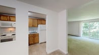Located at 560 N Main St in Leominster, Massachusetts, this single-floor residential unit offers a practical and well-organized layout. The kitchen is equipped with warm oak cabinetry, white appliances including an electric range, built-in microwave, dishwasher, and refrigerator, complemented by a tile backsplash and durable tile flooring. Ample upper and lower cabinet storage provides generous workspace along the countertops.

The living areas feature neutral-toned wall-to-wall carpeting and are bathed in natural light from windows that frame views of surrounding greenery. A sliding glass door in one of the main rooms opens to an outdoor area, fitted with a wall-mounted air conditioning unit for added comfort. Baseboard heating throughout ensures warmth during colder months.

The bedrooms are spacious and carpeted, with clean white walls and easy access to closet space. The unit's open transitions between rooms contribute to a connected and functional flow throughout the layout.

The bathroom includes a full tub-and-shower combination, a vanity with storage, tile flooring, and clean white fixtures. Overall, the unit presents a straightforward and comfortable living environment, well-suited for everyday living in the heart of Leominster.