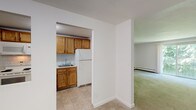 Located at 560 N Main St in Leominster, Massachusetts, this single-floor residential unit offers a practical and well-organized layout. The kitchen is equipped with warm oak cabinetry, white appliances including an electric range, built-in microwave, dishwasher, and refrigerator, complemented by a tile backsplash and durable tile flooring. Ample upper and lower cabinet storage provides generous workspace along the countertops.

The living areas feature neutral-toned wall-to-wall carpeting and are bathed in natural light from windows that frame views of surrounding greenery. A sliding glass door in one of the main rooms opens to an outdoor area, fitted with a wall-mounted air conditioning unit for added comfort. Baseboard heating throughout ensures warmth during colder months.

The bedrooms are spacious and carpeted, with clean white walls and easy access to closet space. The unit's open transitions between rooms contribute to a connected and functional flow throughout the layout.

The bathroom includes a full tub-and-shower combination, a vanity with storage, tile flooring, and clean white fixtures. Overall, the unit presents a straightforward and comfortable living environment, well-suited for everyday living in the heart of Leominster.