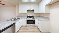 Located at 12801 Rosecrans Ave in Norwalk, CA, this one-bedroom, one-bathroom unit offers a thoughtfully organized single-floor layout. Light wood-style flooring runs throughout, creating a warm and cohesive feel across all rooms.

The kitchen is a standout feature, designed with white shaker-style cabinetry that extends to the ceiling for generous storage. Granite-style countertops wrap around the space and extend into a peninsula that opens to the living area, making it ideal for casual dining or entertaining. A stainless steel gas range sits beneath a skylight that fills the kitchen with natural light, complemented by a dishwasher and stainless steel sink.

The combined kitchen and living room area flows naturally through a hallway toward the bedroom. The living space benefits from a window that draws in natural light and frames an exterior view. The bedroom is a comfortable, well-proportioned room with a window fitted with vertical blinds, light-toned walls, and the same wood-style flooring.

The bathroom features a white vanity with granite-style countertop, a mirror with overhead lighting, and a clean, neutral palette consistent with the rest of the unit. A hallway connects the main spaces and includes an electrical panel. The overall ambiance is clean, bright, and move-in ready.