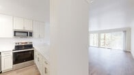 Located at 210 Lower Casitas in the serene Marin County community of Greenbrae, CA, this thoughtfully designed 2-bedroom, 2-bathroom single-floor home offers a clean, modern aesthetic throughout. The open-concept layout seamlessly connects the kitchen, dining, and living areas, creating an airy and cohesive flow. Large sliding glass doors in the living room lead to a private balcony, flooding the space with natural light and framing lush green hillside views.

The kitchen is a standout feature, appointed with white shaker cabinetry, striking quartz countertops with subtle veining, stainless steel appliances including a refrigerator, dishwasher, range, and microwave, plus a pantry for additional storage. Light wood-tone flooring runs throughout, lending warmth and continuity to the space.

Both bedrooms are well-proportioned and bright, each with windows offering natural light and ample closet space — four closets are distributed across the home. The primary bedroom is generously sized with direct access to one of the two bathrooms. Both bathrooms are finished with white cabinetry, quartz vanity surfaces, and clean tile work. The second bathroom features a full soaking tub. The overall ambiance is fresh, light, and move-in ready.