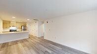 Located at 1000 Sunrise Pl in Burlington, NJ, this two-bedroom, one-bathroom residence offers a clean, modern aesthetic throughout its single-floor layout. Light-toned luxury vinyl plank flooring flows consistently through every room, complementing the crisp white walls and creating a bright, cohesive feel.

The open-concept living area is generously sized, filled with natural light from a large window overlooking the outdoors. It connects seamlessly to the kitchen, which features a peninsula with a light stone-look countertop and an integrated sink, cream-toned cabinetry with brushed hardware, and stainless steel appliances including a refrigerator and electric range.

A hallway leads to both bedrooms and the shared bathroom. The primary bedroom is a well-proportioned retreat with two windows that invite ample natural light and outdoor views. The second bedroom also features multiple doors offering closet access. Both rooms maintain the same clean, neutral palette seen throughout the home.

The bathroom is finished with large-format tile flooring, a combined tub and shower with a beige surround, and accessibility-friendly grab bars. The overall design of this residence prioritizes functionality and modern simplicity, making it a well-appointed home in Burlington, NJ.
