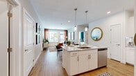 Located at 2275 Chester St in Aurora, CO, this thoughtfully designed 2-bedroom, 2-bathroom residence offers a well-organized single-floor layout that maximizes both comfort and functionality. The open-concept living and kitchen area serves as the heart of the home, where light wood-style flooring flows seamlessly throughout. The kitchen is outfitted with white shaker cabinetry, granite countertops, a subway tile backsplash, stainless steel appliances including a dishwasher, microwave, and range, and a central island with a sink and pendant lighting overhead. The living room benefits from large windows and a glass door that invite abundant natural light and provide outdoor views, creating a bright and welcoming atmosphere. The primary bedroom is a comfortable retreat, featuring plush carpeting, a large window with outdoor views, and direct access to a spacious bathroom equipped with a dual-sink vanity, granite countertops, a soaking tub, and a separate walk-in shower with tile surround. A dedicated walk-in closet adjoins the primary bath. The second bedroom is well-proportioned and similarly carpeted. The second full bathroom mirrors the refined finishes found throughout. A dedicated in-unit laundry room with full-size washer and dryer adds everyday convenience, completing this polished and functional residence.