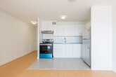 Located at 396 Queens Ave in London, Ontario, this well-appointed 1-bedroom, 1-bathroom unit offers a clean, modern aesthetic throughout. The open-concept layout seamlessly connects the kitchen and living area, creating a functional and airy space. Light wood-tone flooring runs through the living and bedroom areas, complemented by crisp white walls that enhance the sense of brightness.

The kitchen is thoughtfully designed with white flat-front cabinetry extending to the ceiling, a white subway tile backsplash, grey countertops, a stainless steel sink, and stainless steel appliances including a refrigerator and electric range. White tile flooring in the kitchen provides a clean contrast to the rest of the unit.

The living area benefits from a large, wall-spanning window that floods the space with natural light and offers open views of the surrounding neighbourhood's tree-lined streets. A baseboard heating unit is also present in the living area.

The bedroom is a comfortable size, featuring warm hardwood-style flooring and a built-in closet with a hanging rod for ample storage. The bathroom is finished with a full-sized soaker tub and shower combination, white tile surround, and chrome fixtures, maintaining the unit's clean and consistent aesthetic throughout.